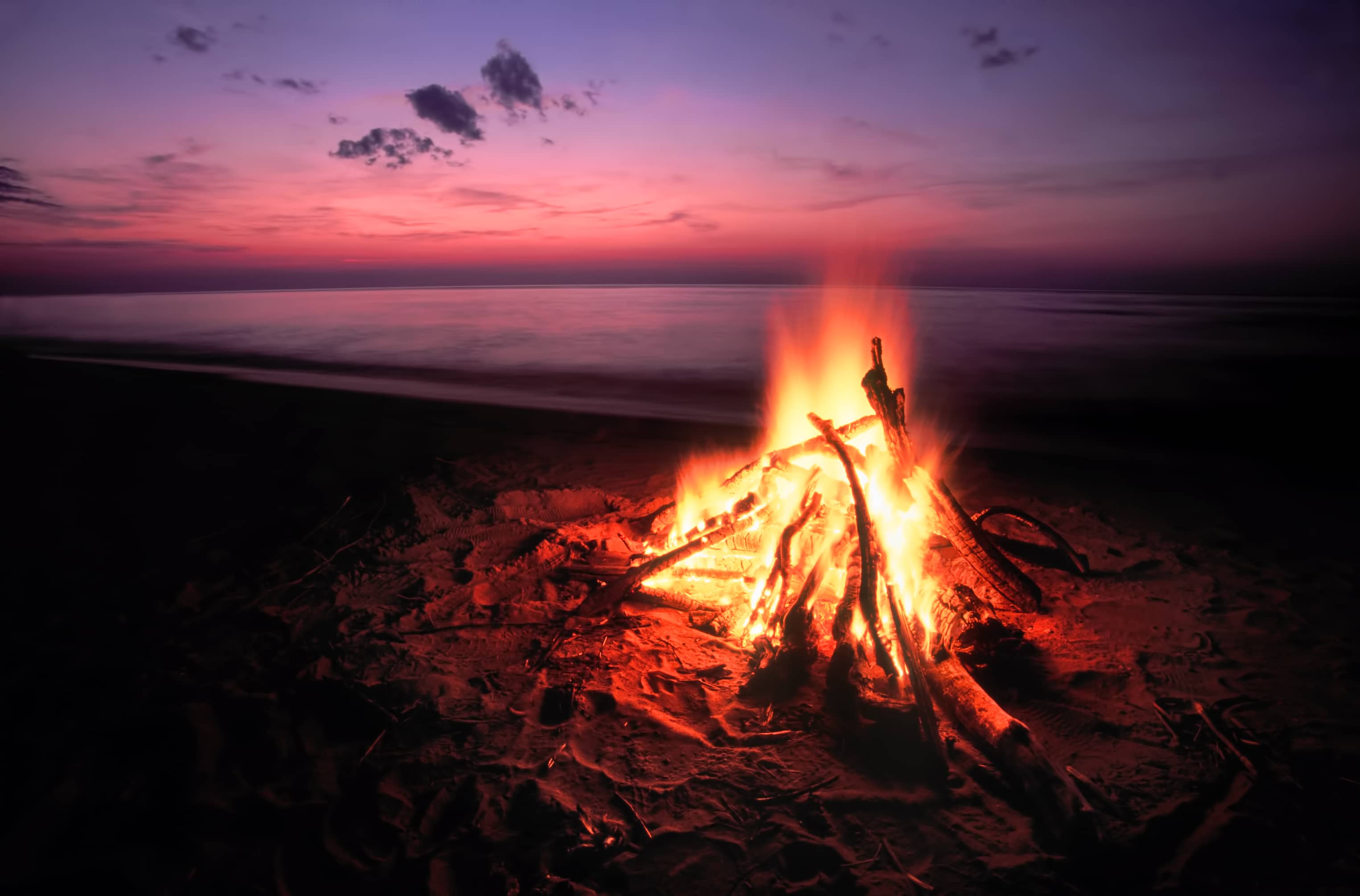 Blazing campfire at sunset along the beautiful beach of Lake Superior in northern Michigan.
